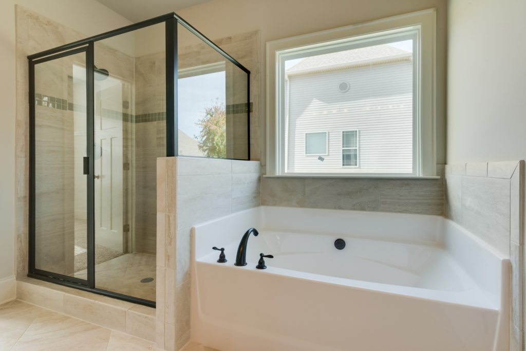 Master Bathroom with Framed Shower Glass and Bronze Accents