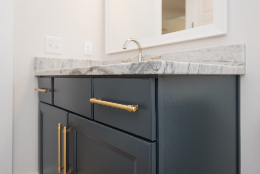 Black with gold handles bathroom counter, single vanity.